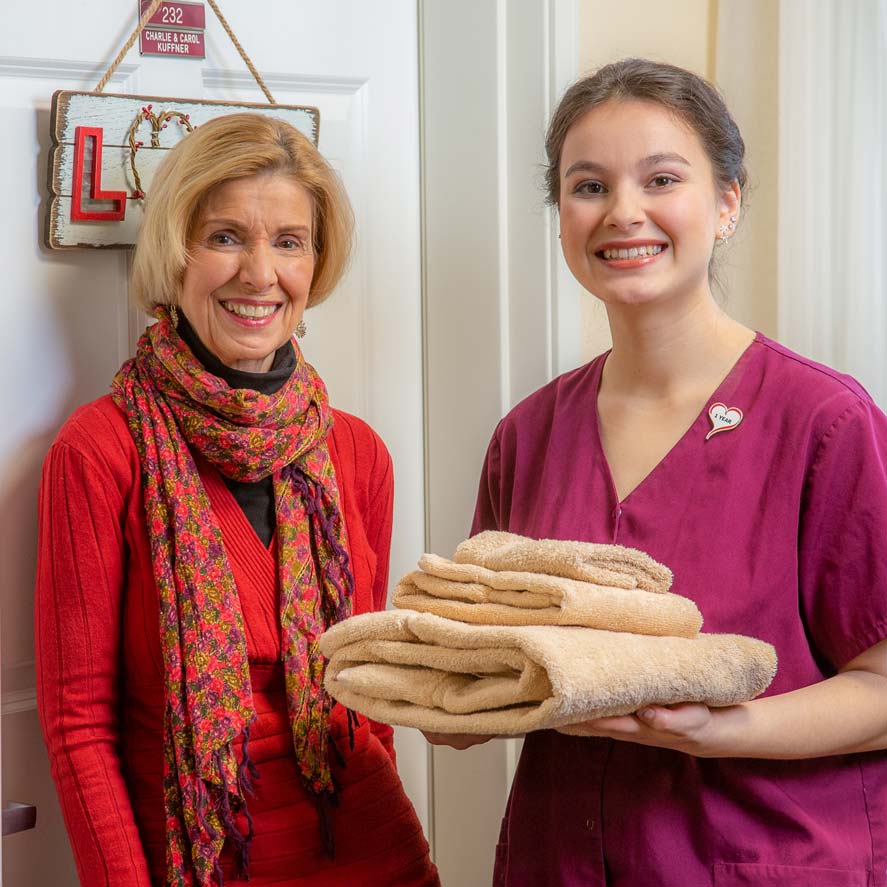 A team member delivering fresh linens to a resident at StoneRidge